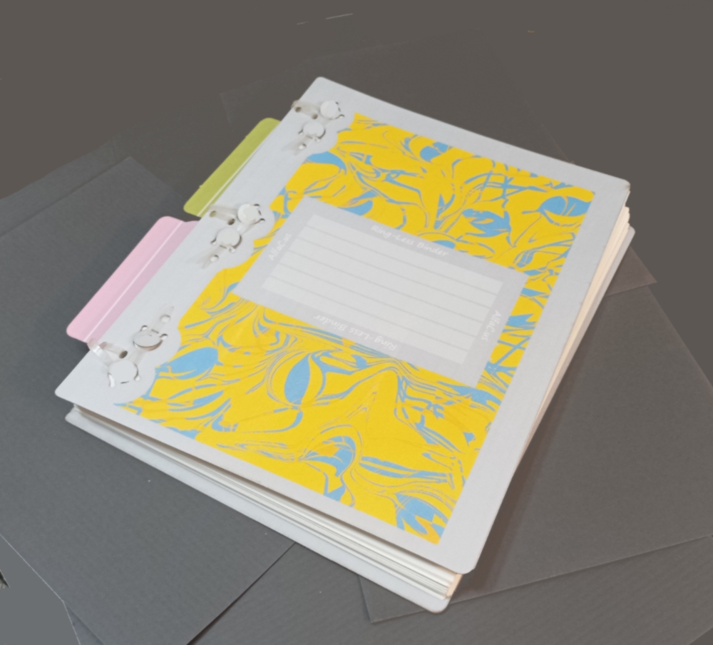 Spineless A4 binder with two sticking out tags showing locations of some pages